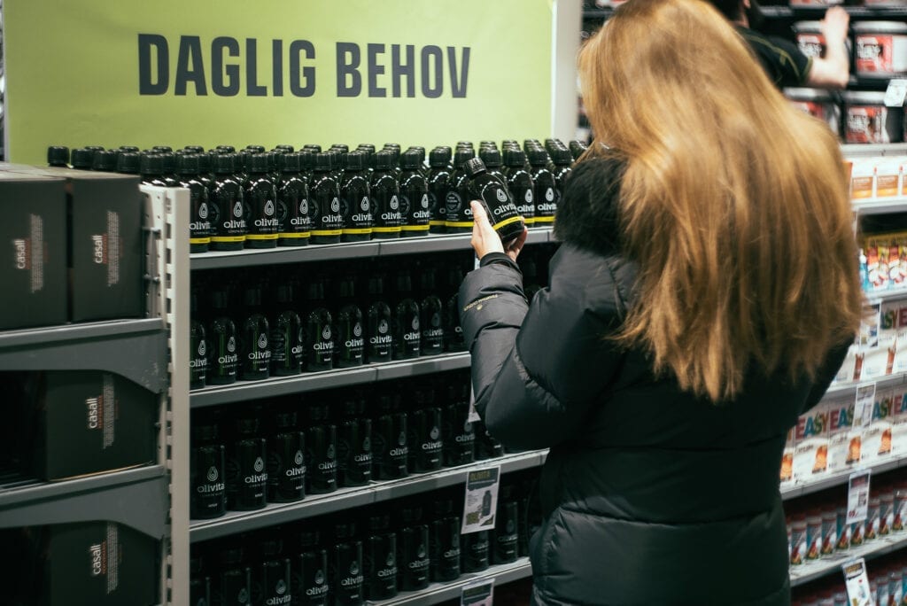 Bilde av kvinne som ser på Olivita omega-3 flaske med sitronsmak